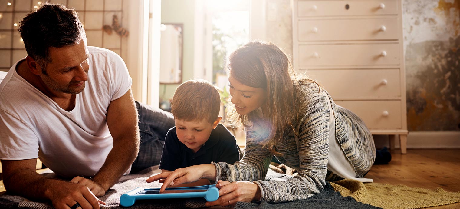 Mom and dad with son on bedroom floor.