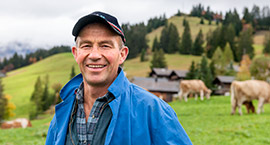 Farmer with cattle in background.
